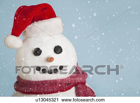 Stock Image - Studio shot of snowman wearing Santa hat. Fotosearch