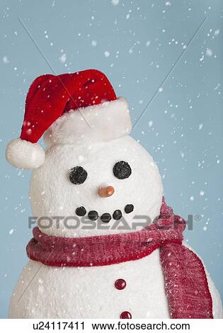 Stock Image - Studio shot of snowman wearing Santa hat. Fotosearch