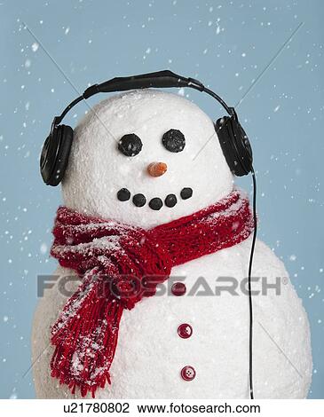 Stock Image - Studio shot of snowman wearing headphones. Fotosearch