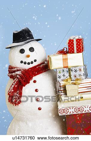 Stock Image - Studio shot of snowman with Christmas presents. Fotosearch
