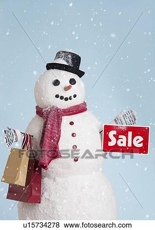 Stock Photo - Studio shot of snowman with shoppings. Fotosearch