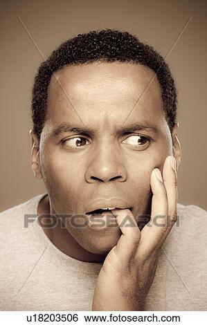 Stock Photograph - Studio shot of surprised mid adult man. Fotosearch