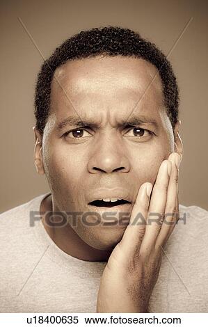 Stock Photography - Studio shot of surprised mid adult man. Fotosearch