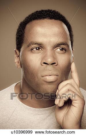Stock Photo - Studio shot of thoughtful mid adult man. Fotosearch