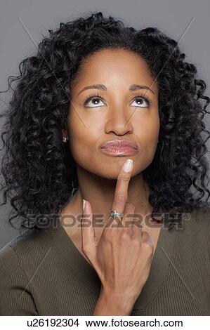 Picture - Studio shot of thoughtful mid adult woman. Fotosearch