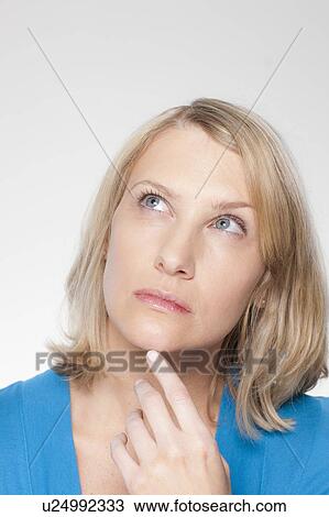 Stock Image - Studio shot of thoughtful mid adult woman. Fotosearch