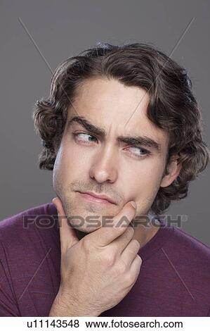 Stock Photo - Studio shot of thoughtful young man. Fotosearch