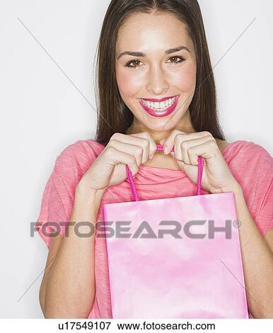 Studio shot of woman holding shopping bag View Large Photo Image Stock Photo - Studio shot of woman holding shopping bag. Fotosearch