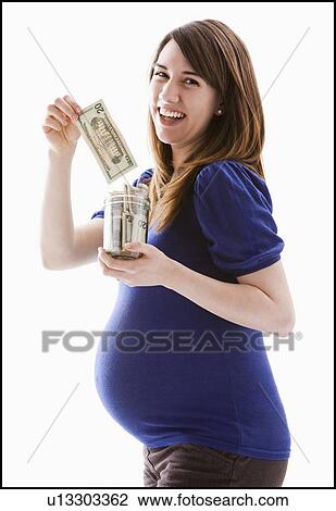 Stock Image - Studio Shot of woman holing baby jar with money. Fotosearch