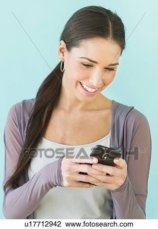 Studio shot of woman using smart phone View Large Photo Image Stock Image - Studio shot of woman using smart phone. Fotosearch