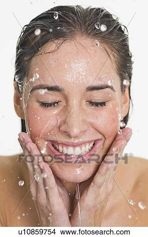 Picture - Studio shot of woman with splash of water on face. Fotosearch