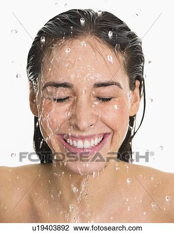 Studio shot of woman with splash of water on face View Large Photo Image Stock Image - Studio shot of woman with splash of water on face. Fotosearch