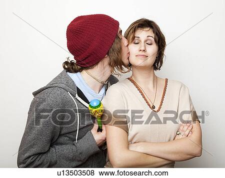 Studio Shot of young man kissing young woman View Large Photo Image Stock Photo - Studio Shot of young man kissing young woman. Fotosearch
