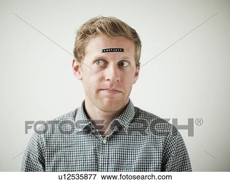 Stock Photo - Studio shot of young man with black concept label on forehead. Fotosearch