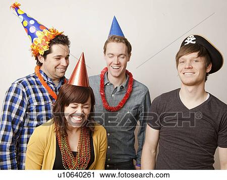Stock Image - Studio Shot of young people dressed up in party hat. Fotosearch