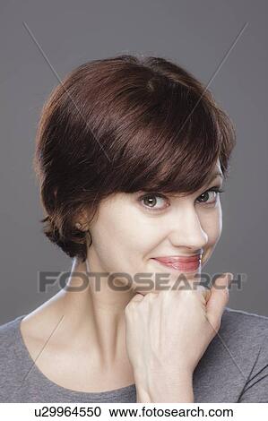 Stock Image - Studio shot of young smiling woman. Fotosearch