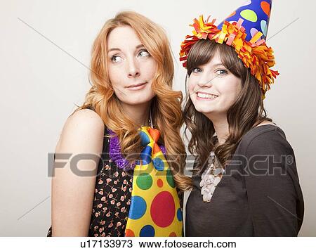 Stock Image - Studio Shot of young woman dressed in party hat. Fotosearch