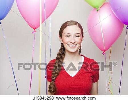 Studio Shot of young woman holding balloons View Large Photo Image Stock Photo - Studio Shot of young woman holding balloons. Fotosearch