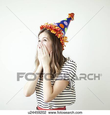 Studio shot of young woman wearing party hat View Large Photo Image Stock Image - Studio shot of young woman wearing party hat. Fotosearch