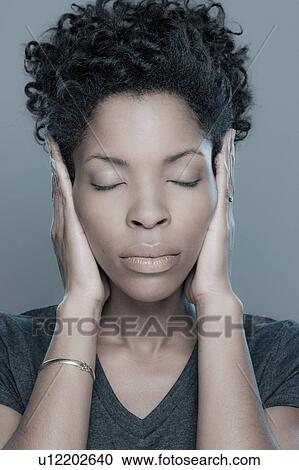 Studio shot of young woman with hands covering ears View Large Photo Image Stock Image - Studio shot of young woman with hands covering ears. Fotosearch