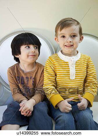 Studio Shot portrait of two boys (4-5, 6-7) sitting side by side View Large Photo Image Stock Photography - Studio Shot portrait of two boys (4-5, 6-7) sitting side by side. Fotosearch