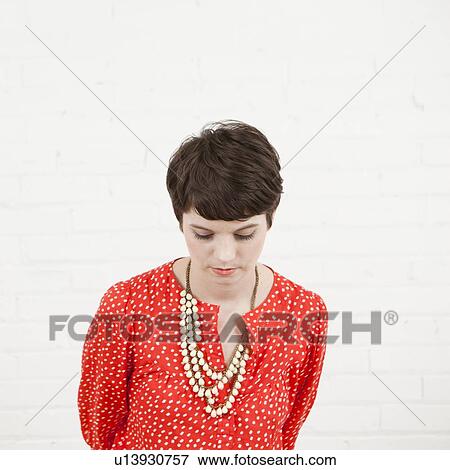 Studio Shot portrait of young woman looking down View Large Photo Image Stock Photo - Studio Shot portrait of young woman looking down. Fotosearch
