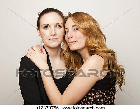 Studio Shot portrait of young women embracing View Large Photo Image Stock Photograph - Studio Shot portrait of young women embracing. Fotosearch