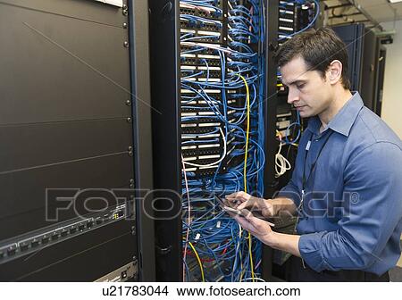 Picture - Technician inspecting network server. Fotosearch