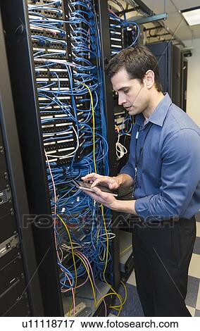 Technician inspecting network server View Large Photo Image Stock Photo - Technician inspecting network server. Fotosearch