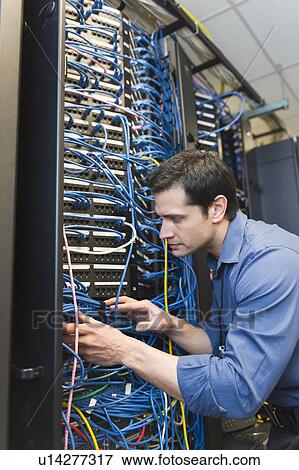 Stock Photo - Technician inspecting network server. Fotosearch