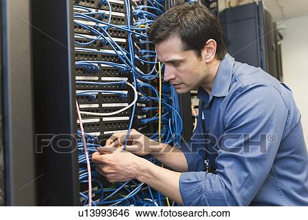 Stock Photograph - Technician inspecting network server. Fotosearch