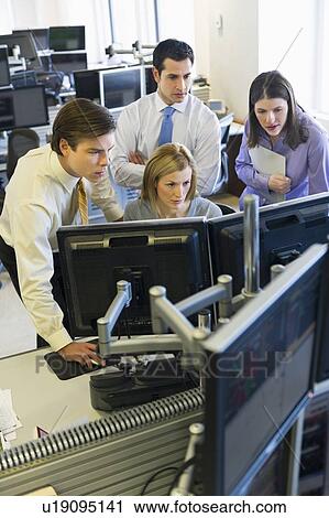 Stock Image - Traders at trading desk. Fotosearch