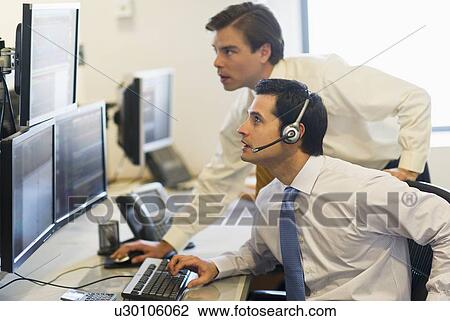 Stock Image - Traders at trading desk. Fotosearch