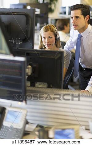 Stock Photo - Traders at trading desk. Fotosearch