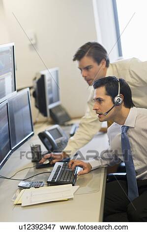 Stock Photo - Traders at trading desk. Fotosearch