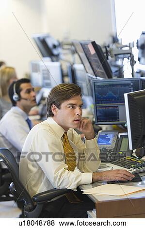 Stock Photo - Traders at trading desk. Fotosearch
