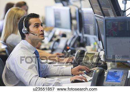 Stock Photo - Traders at trading desk. Fotosearch
