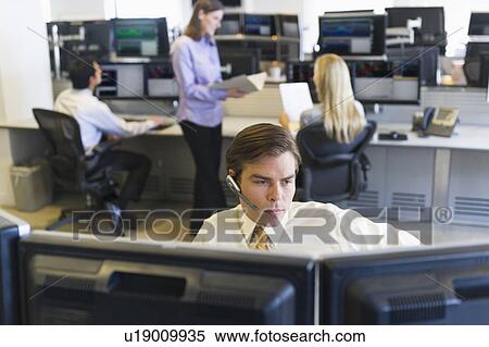 Stock Photography - Traders at trading desk. Fotosearch