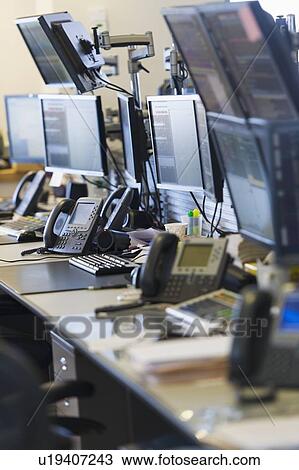 Stock Image - Trading desk with computers and phones. Fotosearch