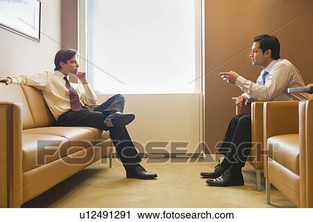 Two businessmen talking in office View Large Photo Image Stock Image - Two businessmen talking in office. Fotosearch