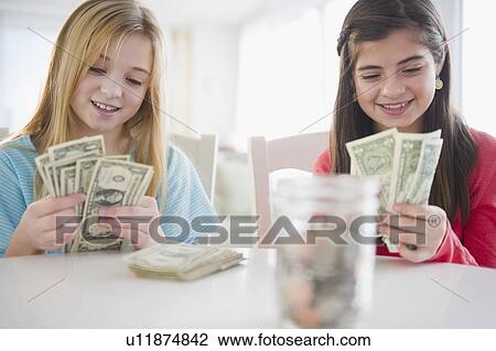 Stock Image -  Two girls counting banknotes. Fotosearch