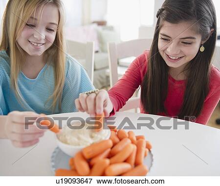 Two girls eating carrots View Large Photo Image Stock Photo - Two girls eating carrots. Fotosearch