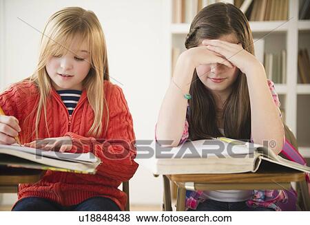 Stock Photo - Two girls learning in classroom. Fotosearch