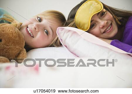 Stock Photo - Two girls lying in bed. Fotosearch