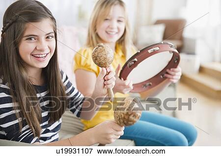 Stock Photo - Two girls playing music on instruments. Fotosearch