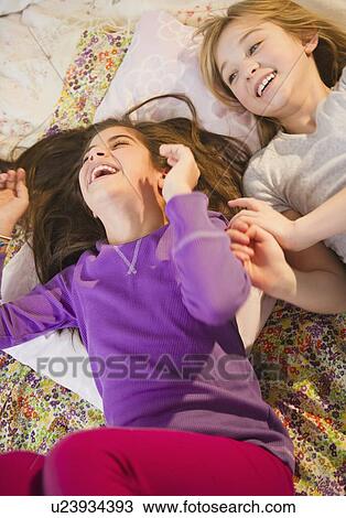 Two girls playing on bed View Large Photo Image Stock Image - Two girls playing on bed. Fotosearch