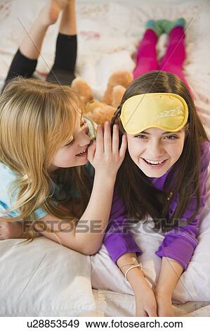 Stock Photo - Two girls playing on bed. Fotosearch
