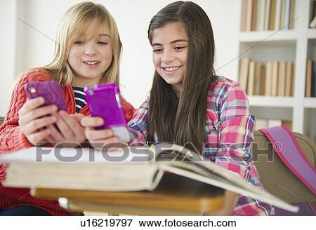 Two girls using mobile phones View Large Photo Image Stock Photo - Two girls using mobile phones. Fotosearch