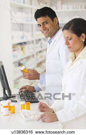 Stock Photograph - Two pharmacists in pharmacy. Fotosearch