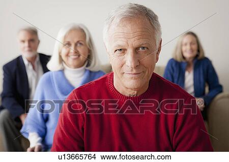 Two senior couples on sofa, smiling man in foreground View Large Photo Image Picture - Two senior couples on sofa, smiling man in foreground. Fotosearch